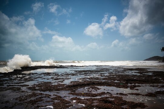 Breathtaking wave crashing into a rocky beach shoreline, creating a dramatic and majestic scene