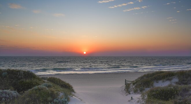 Scenic view of an ocean coast during an orange sunset in Perth, Western Australia