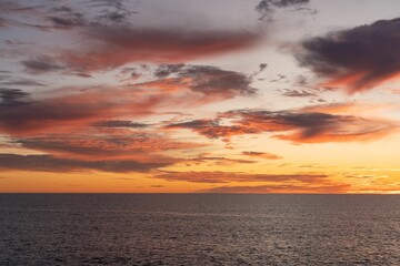 Naklejka na ściany i meble Closeup of a beautiful sunset above a body of tranquil water