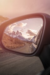 Fototapeta premium Vertical shot of a beautiful scenery of snowy mountains reflected in the car mirror in Chile