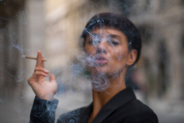 person smoking cigarette. Smoke. Dark background. 