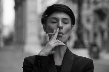 Woman smoking a cigarette. Smoke spread.
