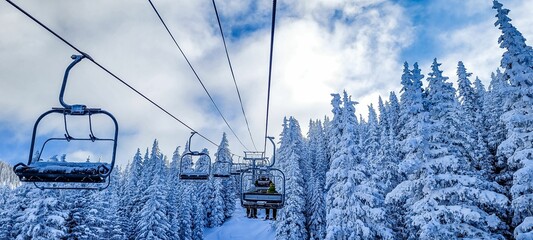 Modern ski lift atop a picturesque snowy mountain slope, providing access to the hillside