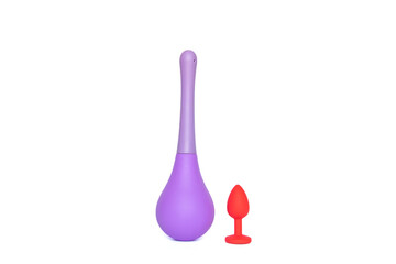 Red silicone smooth butt plug and anal douche, sex toy, on a white background. Contrast photo of anal toys, erotic toys, enema