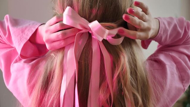 Blonde Teen Girl Braids Hair In Barbie Style, Pink Bow Hairstyle Close-up From Behind Without Face. A Woman Bride Is Preparing For A Bachelorette Party