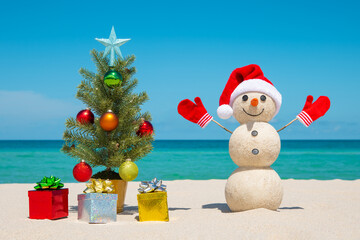 Christmas Tree and Snowman. Sandy snowman on the beach. Merry Christmas. Happy New Year. Smiling...