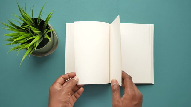 top view of man's hand turning a pager of a diary 