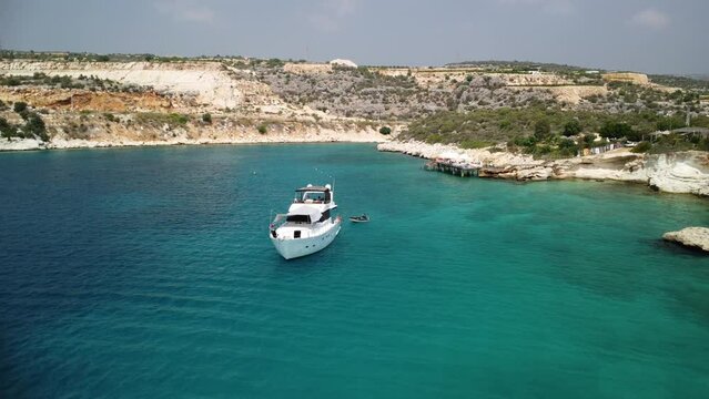 Drone shot of a white yact sailing off the coast of Turkey.