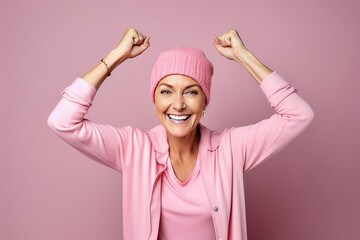 Fototapeta na wymiar Woman 40 years old fighting cancer, dressed in a pink cap, gesturing strength and victory.