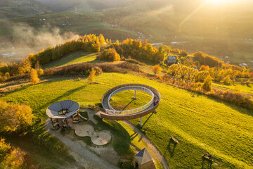 Aerial view of a wooden lookout tower in autumnal mountains at sunset in Poland - 636800659