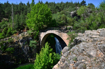 Fototapeta na wymiar Clandiras Bridge, located in Usak, Turkey, was built during the Roman period. There is a waterfall right next to it.