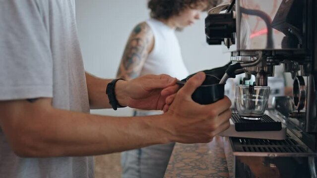 Unrecognizable barista preparing coffee on modern machine in restaurant close up
