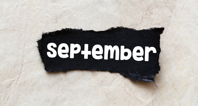 SEPTEMBER word on a small piece of paper.