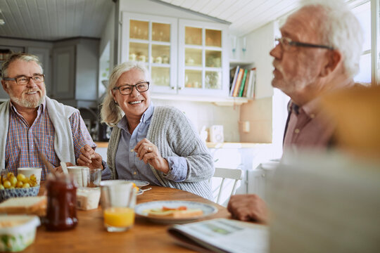 Senior people having breakfast together at home in a nordic styled kitchen