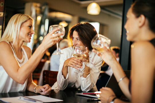 Group of businesswoman having wine in a cafe bar after work