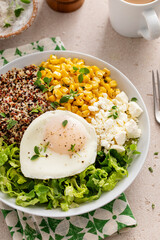 Breakfast bowl with quinoa, herbed corn, feta cheese and fried egg