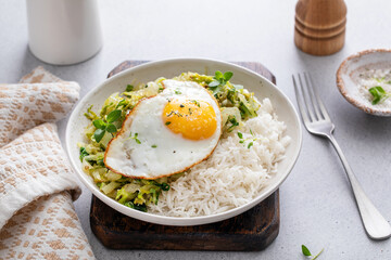 Rice bowl with sauteed cabbage and fried egg, healthy lunch or breakfast idea