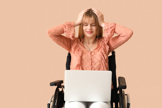 Stressed young woman with laptop in wheelchair on beige background - Powered by Adobe
