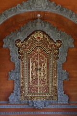 In die Wand eingelassener Opferschrank mit goldenen Ornamenten und Figuren in Bali, Indonesien