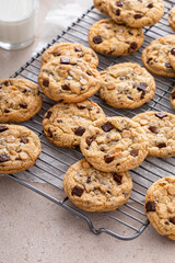 Chocolate chip cookies on a cooling rack with flaky salt served with milk
