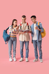 Happy students with backpacks, cup of coffee and mobile phone on pink background