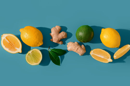 Fresh lemons with ginger roots and lime on blue background