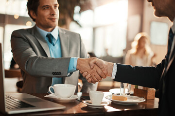 Two businessmen having a handshake in a cafe bar decorated for christmas and the new years holidays