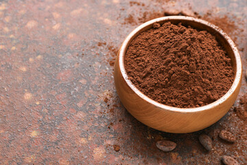 Bowl with cocoa powder on grunge background