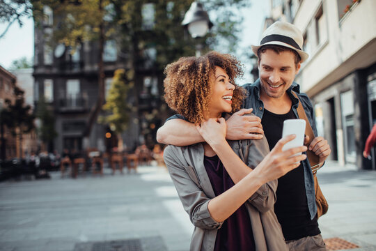 Young mixed couple walking and exploring the city