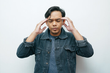 Portrait of an Asian Indonesian man put his hands on head for headache gesture. Isolated white background