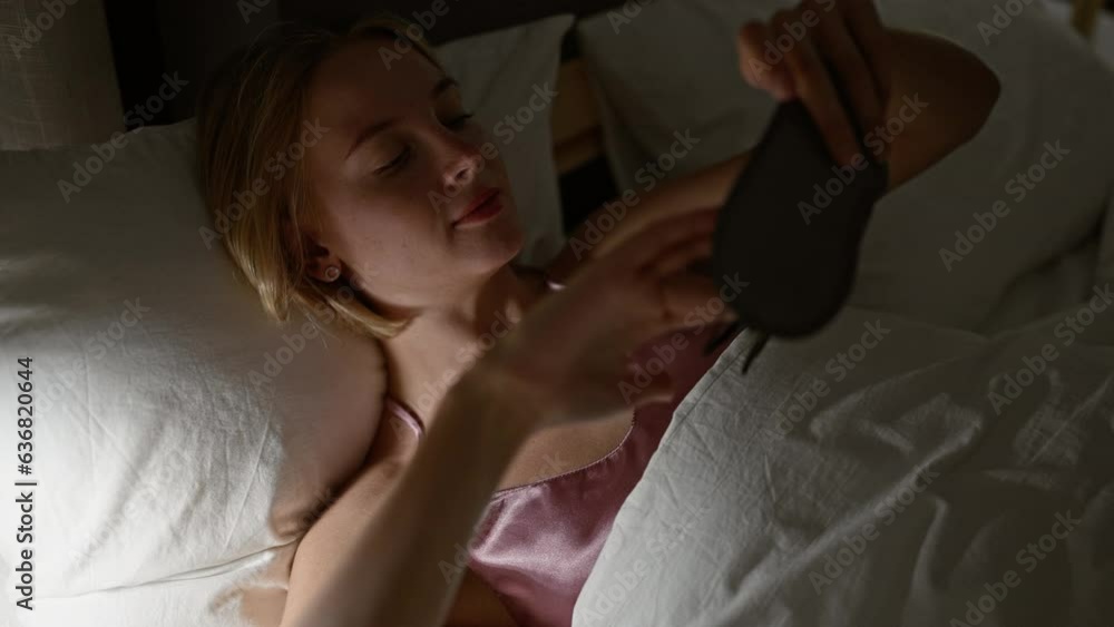 Sticker young blonde woman wearing sleep mask to sleep at bedroom