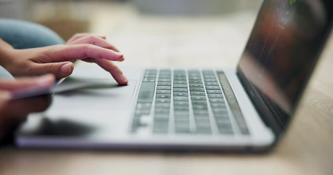 Person, laptop and hands typing with credit card in online shopping, payment or banking on desk at home. Closeup of shopper with debit or filling bank details on technology in ecommerce on table