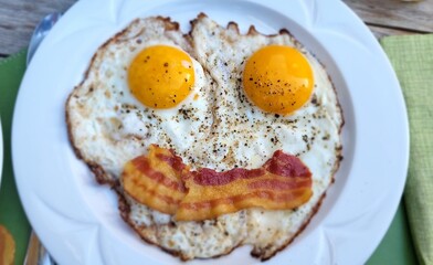 Smiley fried egg with bacon