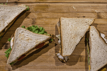 Foto von einem Sandwich mit Tomate, Ei, Gurke und Salat auf einem Brett mit Zahnstocher von oben fotografiert Photo of a sandwich with tomato, egg, cucumber and lettuce on a board with toothpick