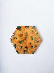Handmade resin coaster with floral pattern on white background. Selective focus.