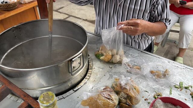 Street food booth selling Bakso which is Indonesian meatball with beef stock soup and many other condiments