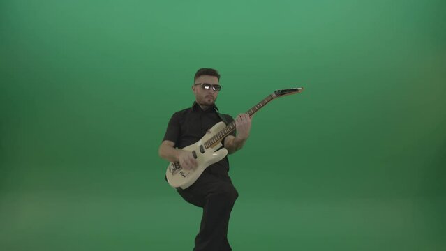 Man in black costume virtuoso play white electro rythm guitar isolated on green screen