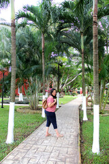 40-year-old Latina woman walks through the cobbled colonial streets of the garden of a Latin American town happy and relaxed enjoys the sunny day in tranquility