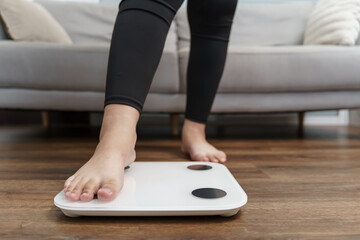 Fototapeta premium Fat diet and scale feet standing on electronic scales for weight control. Measurement instrument in kilogram for a diet control.