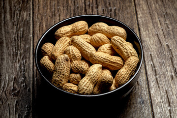 Peanuts with nutshell on a bowl, studio shot