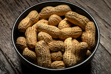 Peanuts with nutshell on a bowl, studio shot