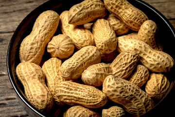 Peanuts with nutshell on a bowl, studio shot