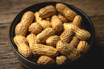 Peanuts with nutshell on a bowl, studio shot