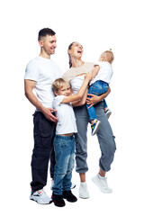 Happy family with children stand in full growth. Laughing mom, dad, little son and daughter in white t-shirts and jeans are hugging. Love and tenderness. Full height. Isolated on white background. 