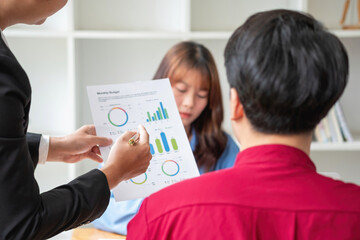 Asian business team consists of marketing staff. accountant and financial officer Help each other analyze company profits using tablets. calculator Laptop computers, graph paper, and corporate pens.