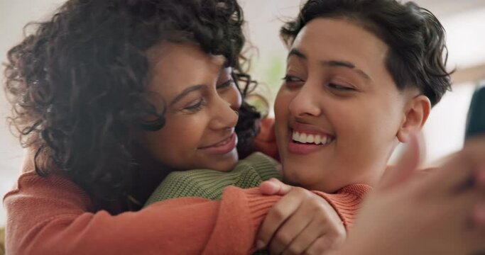 Lgbtq couple, hug and women on sofa in home for bonding, connection and relax together. Love, lesbian and happy people in living room embrace for commitment, romance and trust with smartphone
