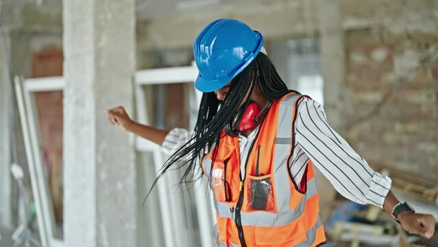 African american woman builder smiling confident dancing at construction site