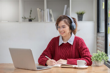 Asian female student study online in class, study online, wearing headphones, watching video call, zooming, happy asian female learning language online with computer laptop.