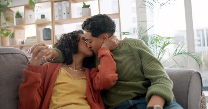 Love, home and lesbian couple kiss, smile or care for bisexual, non binary or homosexual gen z people on living room sofa. LGBTQ, connection and gay women bonding, happy and enjoy relax time together