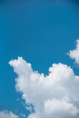 white clouds in the sky against a clear day.